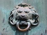 Detail of a door knocker of a lions head with a ring in its mouth on a door in Paris